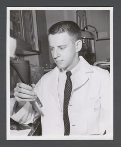 School of Dentistry, 1960s - Dental student [?[ Hood holding a vial