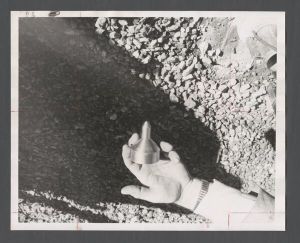 Lullwater Radiation Center - Unidentified person holding metal object while standing over gravel