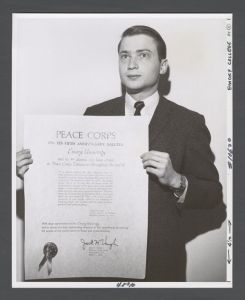Students, individuals - Ronald Carlisle holding a certficate signed by Peace Corp Director Jack Vaughn, recognizing Emory University for its response to the Peace Corps