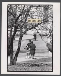 Candid campus photographs with unidentified individuals - Students talking behind tree