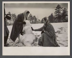 Unusual weather on campus - Two women build a snowman by the gym