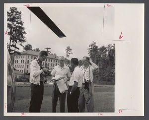 Aerial campus photographs - Photographers, editor, and pilot near landed helicopter
