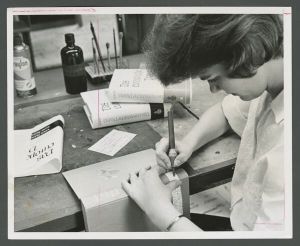 Library - Cathy Swanson in the Cataloging department marks the classification numbers on spine of a book
