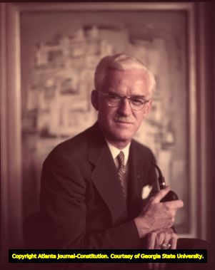 Southern painter Lamar Dodd poses with his artwork, 1954