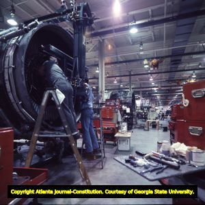 Delta Air Lines' mechanics working on an airplane engine, 1977