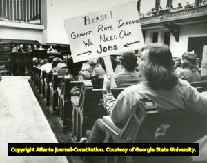 Woman holds sign urging Georgia Power Company's request for a rate increase, Atlanta, Georgia, 1975.