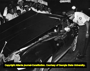 Atlanta police officers respond to a car crash; 1965