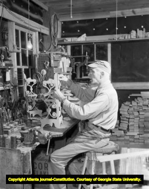 Toymaker constructing toys in his woodshop, 1946