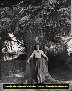 Faye McFerrin, leaning against the "Hester redwood," believed to be planted in 1848, Georgia, 1940s?