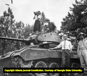 Photojournalist Carolyn Carter of the Atlanta Journal on a tank, 1950