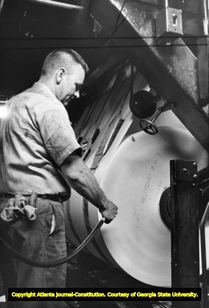 Roll of newsprint is prepped for printing an issue of the Journal Constitution, 1966