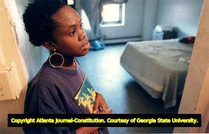 Woman looks over substandard public housing apartment where she and her family live in unsanitary conditions, Techwood Homes, Atlanta, Georgia, October 28, 1993.