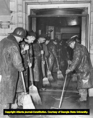 Firefighters sweep excess water out of the Winecoff Hotel lobby after a fire, 1946