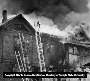Burning house on Haynes Street, Castleberry Hill, Atlanta, Georgia, December 1954.