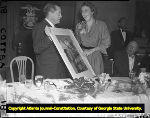 Golfer Bobby Jones presents Dorothy Kirby with a photograph, 1951
