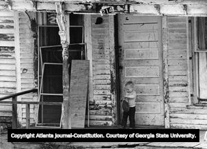 Child on front porch of substandard house, Chestnut Street, Lawrenceville, Georgia, March 13, 1981.