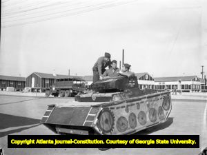 Soldiers driving a fake tank around Fort Benning, 1942
