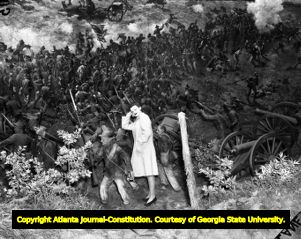 Woman stands among the Confederate model army at the Atlanta Cyclorama, 1940s