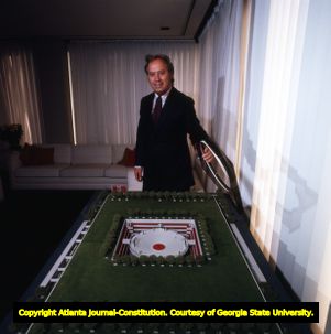 Architect John Portman showing off an architectural model, 1971