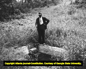 Moore's Ford Bridge mass lynching, July 25, 1946. Unidentified man pointing his cane at hole, Walton County, Georgia.