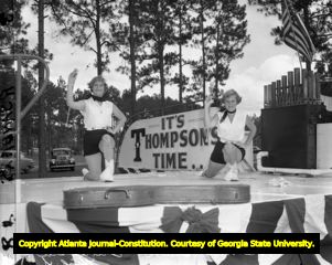 M. E. Thompson performers with a "It's Thompson Time" sign, 1954