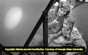Fernbank Museum patrons watch the partial solar eclipse through projections on a screen, 1986