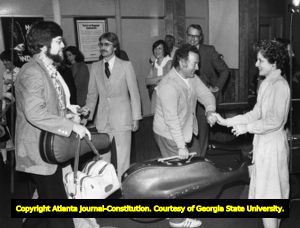 Board Director Betty Fuller of the Atlanta Symphony Orchestra greets musicians returning from a concert tour, 1978