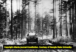 Good Road Tour automobile traveling through a wooded area, 1910