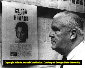 Sergeant Helms looks over a reward poster for information on the Mary Little kidnapping case, 1966