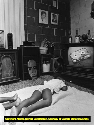 Child sleeping inside an apartment at the McDaniel-Glenn housing project, 1978