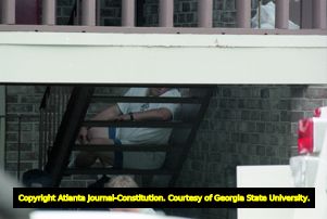 Richard Jewell waits on his apartment complex steps while FBI investigators search his home, 1996