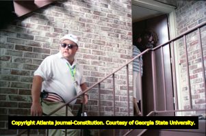 Richard Jewell attempts to leave his apartment surrounded by journalists questioning his involvement with the Centennial Olympic Park bombing, 1996