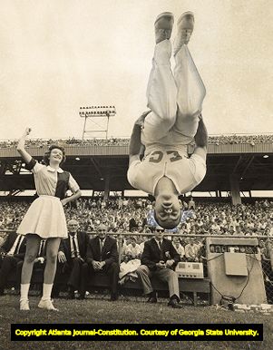 Georgia Tech cheerleaders doing flips for the Yellow Jackets during a game, 1962
