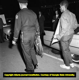 Demonstrators hold signs on voting rights while Gov. George Wallace visits Atlanta, 1963