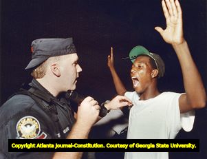 Atlanta Police Officer Dave Studdard with the Red Dog Unit searching a teenager for drugs, 1990