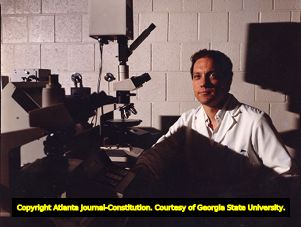 Crime lab technician Larry Peterson with the microscope used to match carpet fibers in the Wayne Williams trial, 1991
