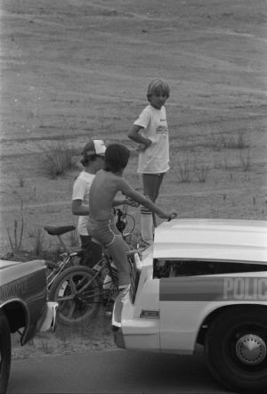 Onlookers watch from the road near the Chattahoochee River where the body of Nathaniel Cater was found, 1981