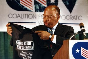 Representative John Lewis receiving a shirt reading "President Bush went to Rome, and all I got was this lousy recession," 1991