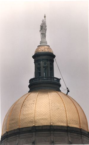 Georgia State Capitol dome, with steeplejack Darrell O'Neil suspended from a rope, cleaning the gold-gilt, Atlanta, Georgia, June 16, 1993.