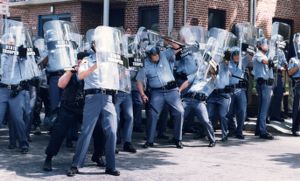 Police officers at Atlanta University Center protecting themselves against objects thrown by Rodney King demonstrators, 1992