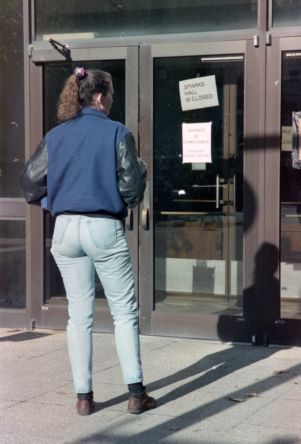 Georgia State University student reads a sign stating "Silence is compliance, speak out against racism," during a sit-in demonstration in Sparks Hall, 1992