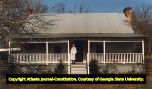 Dr. Leila Denmark stands on the front porch of her home and pediatric office, 1992