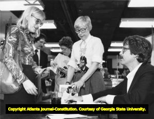 Columnist and author Lewis Grizzard signing copies of his book "Kathy Sue Loudermilk, I Love You" for fans, 1980s
