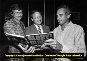 Georgia Bulldog coach Vince Dooley, with Loran Smith, signing a copy of author Lewis Grizzard's book,1981