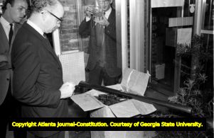 Segregationist Lester Maddox with a box of axe handles for use of customers to bar African-Americans from entering the Pickrick restaurant, 1964