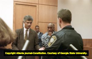 Tupac Shakur listens as his lawyer and an officer testify during a trial involving a shooting incident in Midtown, 1993