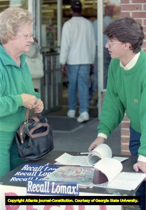Volunteer Gabriel Sterling of the Task Force for Good Government talks with supporters while running a "Recall Lomax" petition table, 1991