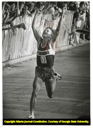 Runner Jon Sinclair crossing the finish line of the Peachtree Road Race in first place, 1982
