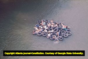 Ramblin' Raft Race down the Chattahoochee River, Atlanta, Georgia, May 21, 1977. Raft made of various sized tire inner-tubes tied together, in the river.