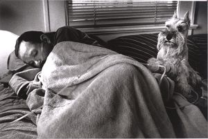 Tom Fox hooked up to his portable oxygen tank, shivering and unable to get out of bed -- with his dog, Sassy, Atlanta, Georgia, 1989.